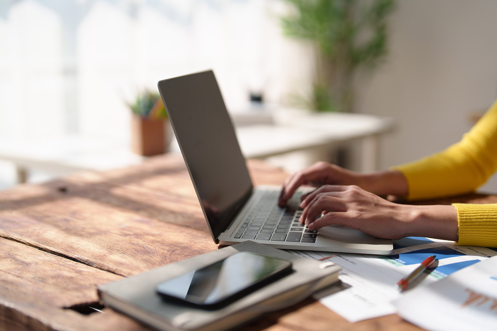 A founder at the table during a briefing session &mdash; laptop, notebook, calm focus